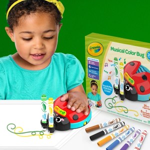 A young girl uses the Crayola Musical Color Bug doodlebug toy to draw on paper while the packaging sits next to her